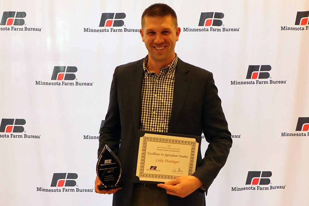 Excellence in Ag award winner Luke Daninger holding award